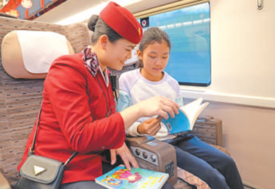 從北京開往南昌的列車上，乘務(wù)人員與小旅客一起閱讀。王夢(mèng)婧子攝