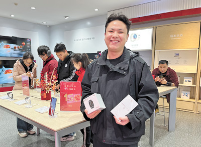 馬瑞晨展示購(gòu)買(mǎi)的手機(jī)和智能手表。　本報(bào)記者 姚雪青攝